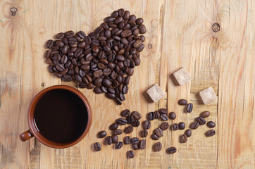 Cup of coffee and heart made from beans