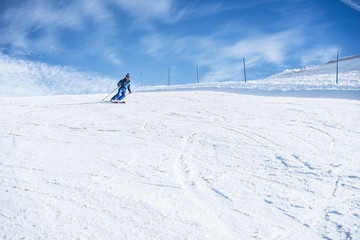 Fototapeta na wymiar Young man skiing in alps mountains on sunny day - Skier training during winter season - Extreme sport and vacation concept