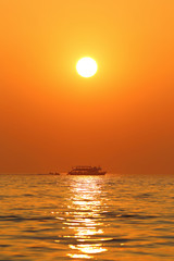 Sunset seascape with boat and jet skis in Thailand