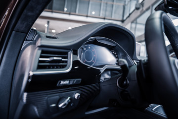 Fototapeta na wymiar Close up of wheel inside new modern car with leather interior