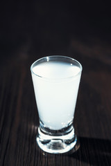 Vodka in shot glasses on rustic dark background