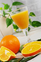 orange and glass of orange juice on white wooden table