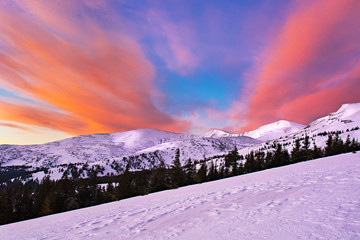 Beautiful colorful skies over mountain slopes covered with snow