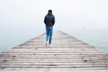 young boy walks on the pier