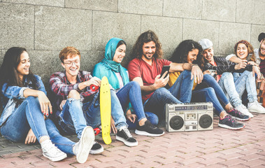 Group of millennials friends using smartphones and listening music outdoor