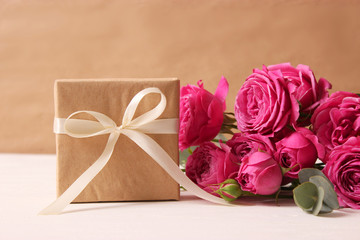 gift and flowers on a colored background. Holiday, give a gift, congratulations. Valentine's Day, Mother's Day, International Women's Day.