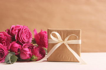 gift and flowers on a colored background. Holiday, give a gift, congratulations. Valentine's Day, Mother's Day, International Women's Day.