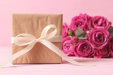 gift and flowers on a colored background. Holiday, give a gift, congratulations. Valentine's Day, Mother's Day, International Women's Day.