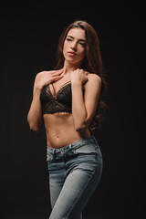 attractive young woman posing in lace bra isolated on black