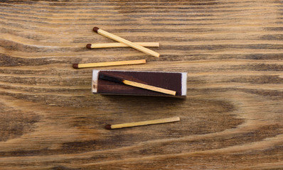 Matches with gray and burnt match on the verge of a matchbox