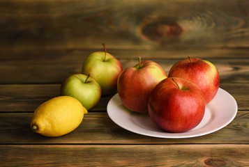 Still life with apples and lemon on a wooden rustic table