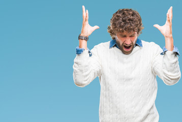 Fototapeta premium Handsome hispanic man model wearing winter sweater over isolated background celebrating mad and crazy for success with arms raised and closed eyes screaming excited. Winner concept