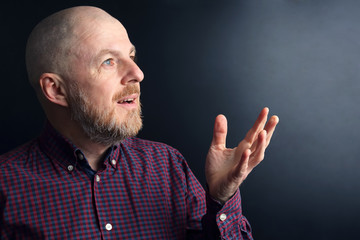portrait of a bearded man with his hand raised to the light