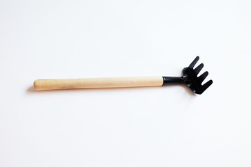 Tool for horticulture, agriculture, farming. Soil cultivator, rake for cultivating the land.Gardening tools.Garden Lawn Hand Cultivator Rake isolated on white background.Metal rake with wooden handle