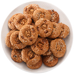 Homemade oatmeal cookies with nuts, chocolate chips and sesame. Isolated on white background. View from above.