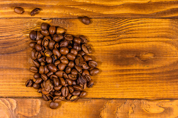 Pile of the coffee beans on wooden table. Top view