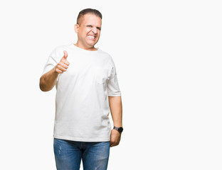 Middle age arab man wearig white t-shirt over isolated background doing happy thumbs up gesture with hand. Approving expression looking at the camera showing success.