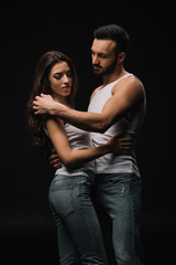 seductive loving couple hugging isolated on black