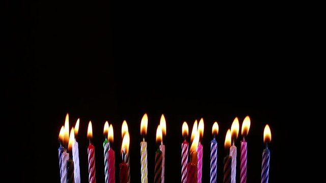 birthday candles light on isolated black