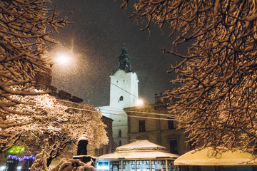 highlighted church tower at night in winter snowstorm