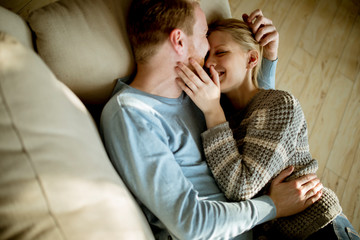 Loving couple lying down on the sofa in the room