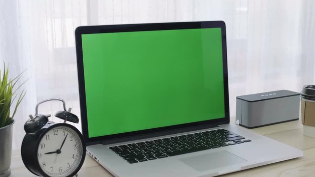 4K Green screen of laptop computer set on working space in cozy office, Zoom in shot