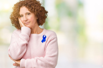 Fototapeta na wymiar Middle ager senior woman wearing changeable blue color ribbon awareness over isolated background thinking looking tired and bored with depression problems with crossed arms.