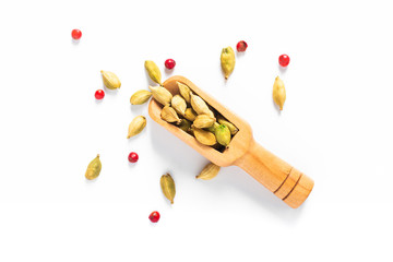 Exotic spices  Organic cardamom and pink peppercorn pods in bamboo scoop on white background