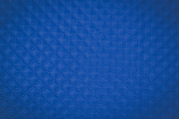 Blue quilted fabric. The texture of the blanket 