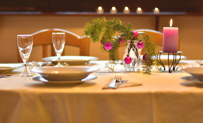 Celebration. A colorful laid table decorated different in purple with xmas decoration for a christmas dinner in the dining-room indoors at home
