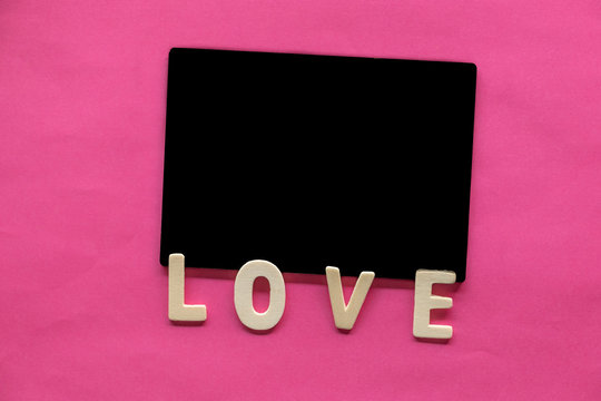 Blackboard with word LOVE on pink background, Love icon, valentine's day, relationships concept with copy space