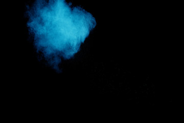 Naklejka na ściany i meble Blue color powder explosion cloud on black background.Closeup of Blue dust particles exhale on dark background.