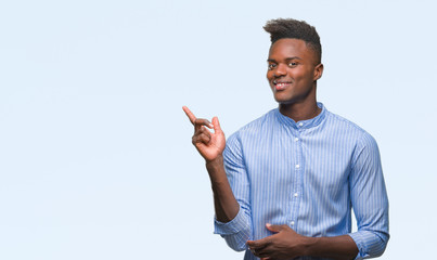 Young african american business man over isolated background with a big smile on face, pointing with hand and finger to the side looking at the camera.
