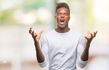Young african american man over isolated background crazy and mad shouting and yelling with aggressive expression and arms raised. Frustration concept.
