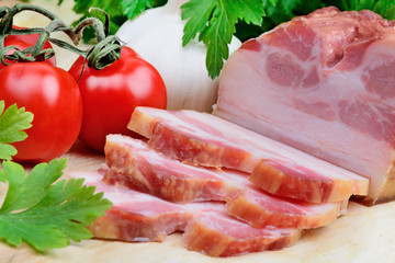 Bacon with cherry tomatoes,parsley and garlic on table