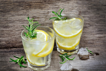 Fresh lemon with water in a glasses on table