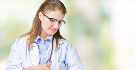 Middle age mature doctor woman wearing medical coat over isolated background In hurry pointing to...
