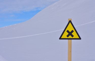 Yellow warning sign posted at ski resort. A sign that points to intersections on the ski slope.
