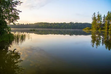 Poster Im Rahmen Wilderness Lake Sonnenaufgang. Sonnenlicht leuchtet über den Horizont eines Wildnissees im Norden von Michigan. Horizontale Ausrichtung mit Kopienraum im Vordergrund. © ehrlif