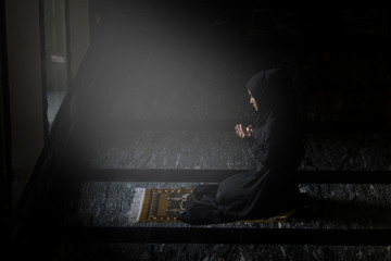 Muslim women wearing black shirts Doing prayer According to the principles of Islam..