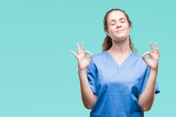 Young brunette doctor girl wearing nurse or surgeon uniform over isolated background relax and smiling with eyes closed doing meditation gesture with fingers. Yoga concept.