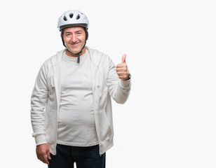 Handsome senior cyclist man wearing bike helmet over isolated background happy with big smile doing ok sign, thumb up with fingers, excellent sign