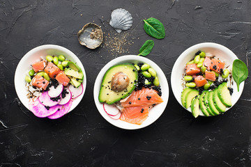 Fresh seafood recipe. Salmon gravlax poke bowl with fresh prawn, brown rice, cucumber, pickled sweet onion, radish, soy beans edamame portioned with black and white sesame. Food concept poke bowl