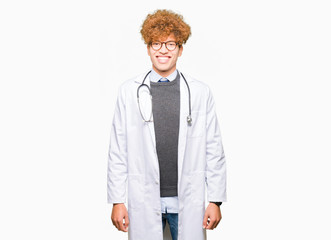 Young handsome doctor man wearing medical coat with a happy and cool smile on face. Lucky person.