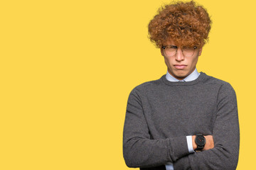 Fototapeta na wymiar Young handsome business man with afro hair wearing glasses skeptic and nervous, disapproving expression on face with crossed arms. Negative person.