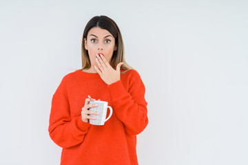 Young woman drinking cup of coffee over isolated background cover mouth with hand shocked with shame for mistake, expression of fear, scared in silence, secret concept