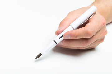 Men's hand holding white fountain pen on isolated backgroung, close up