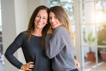 Beautiful family of mother and daughter together, hugging and kissing at home