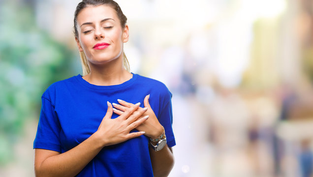 Young beautiful woman wearing casual blue t-shirt over isolated background smiling with hands on chest with closed eyes and grateful gesture on face. Health concept.