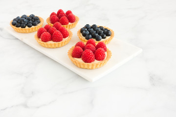 Blueberry and Raspberry Tarts on Marble Board